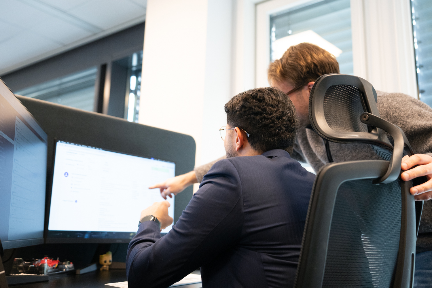 To rådgivere hos Samle gjeld ser på skjerm og diskuterer kundesak